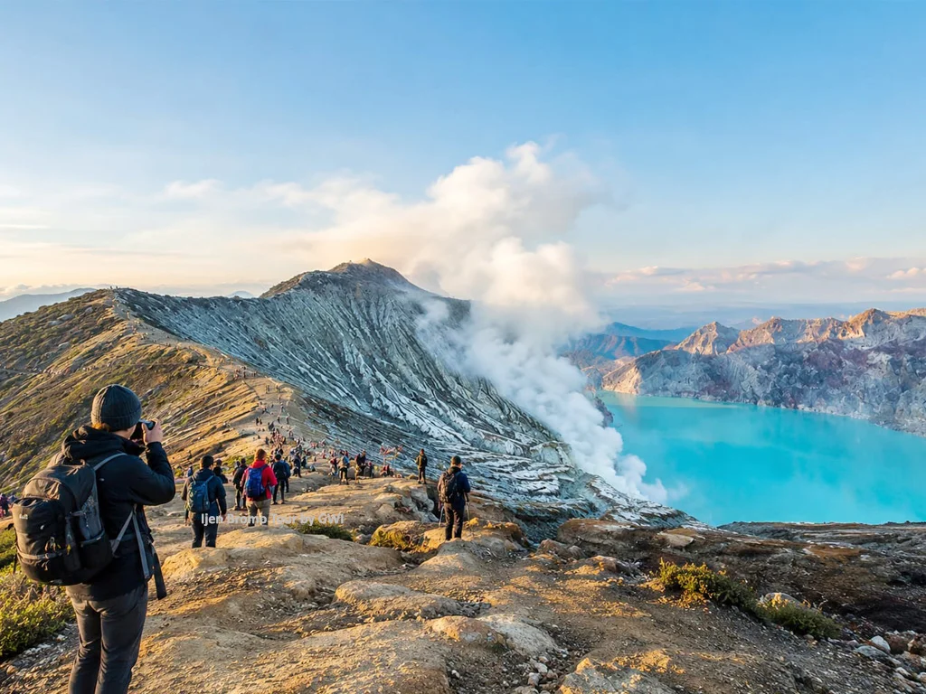 Panoramic Ijen crater summit views showing turquoise acidic lake and sulfur miners get around the rim trail